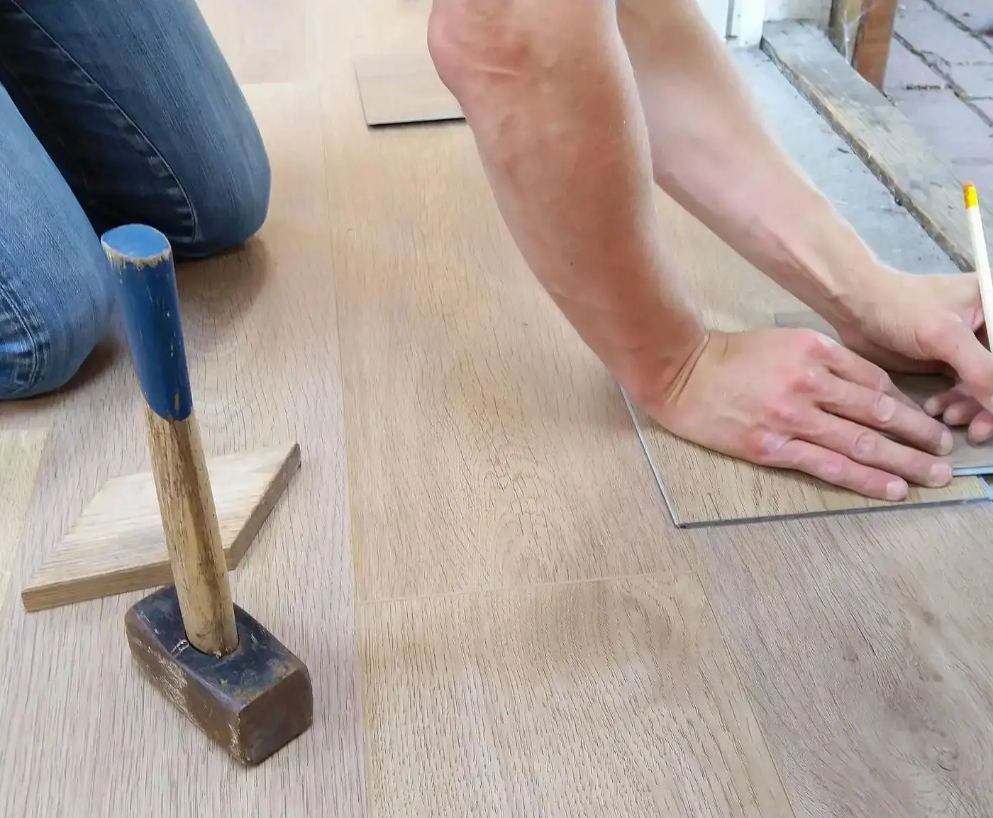 a worker measuring the floor angles to fit flooring