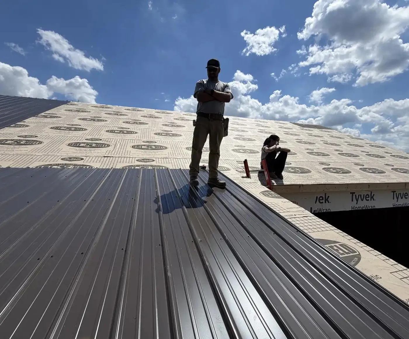 workers atop a roof built with metal.