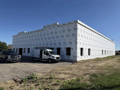 building wrapped with utilities vehicles parked outside